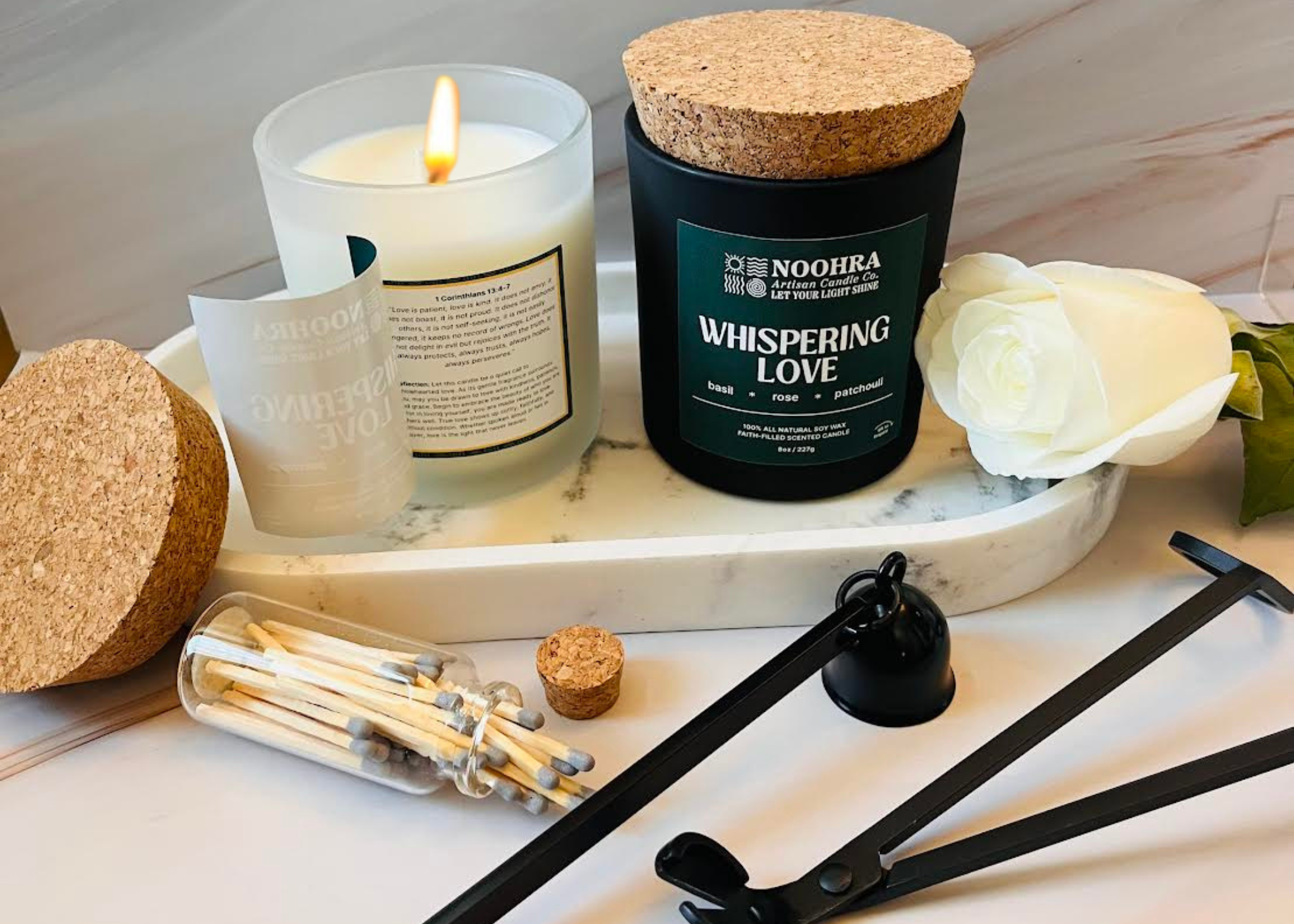 Candle, matches, and decorative items on a marble surface with 'Noohea' branding.