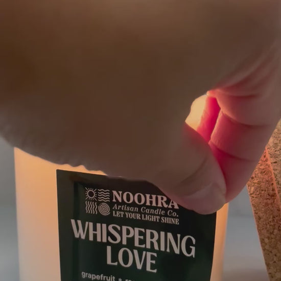 A candle that says Whispering Love